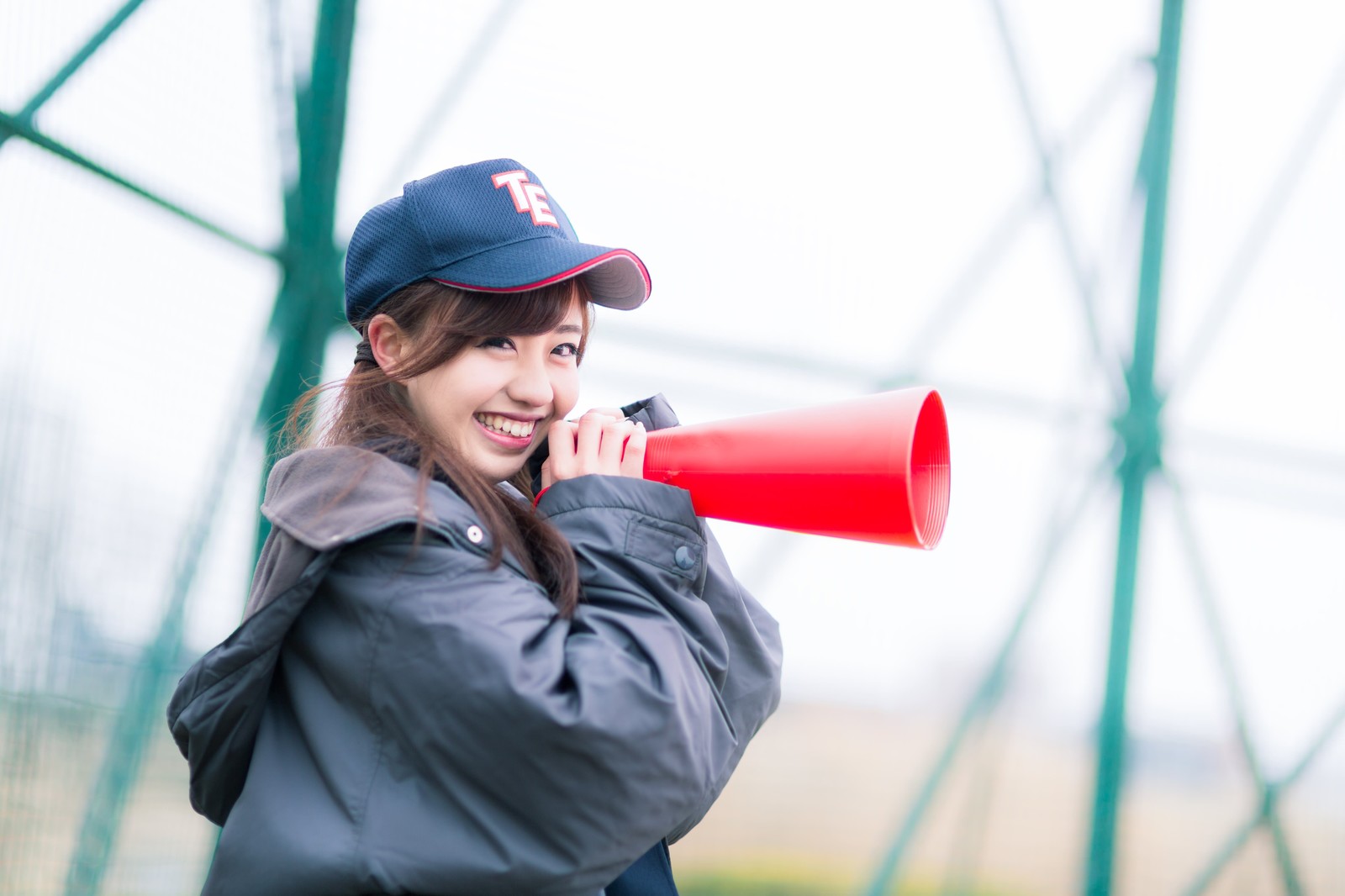 笑顔で野球の応援をする女子