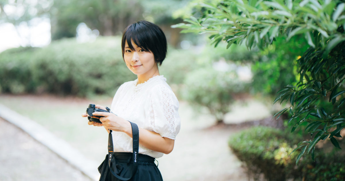笑顔で会釈するカメラ女子