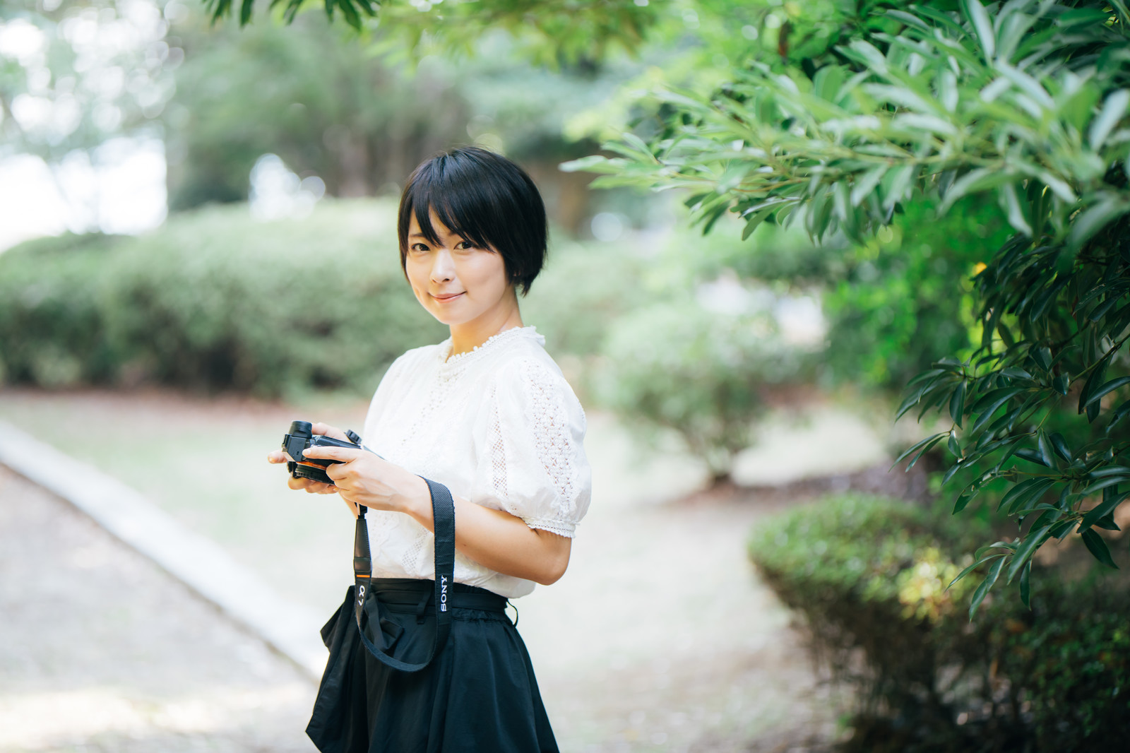 笑顔で会釈するカメラ女子