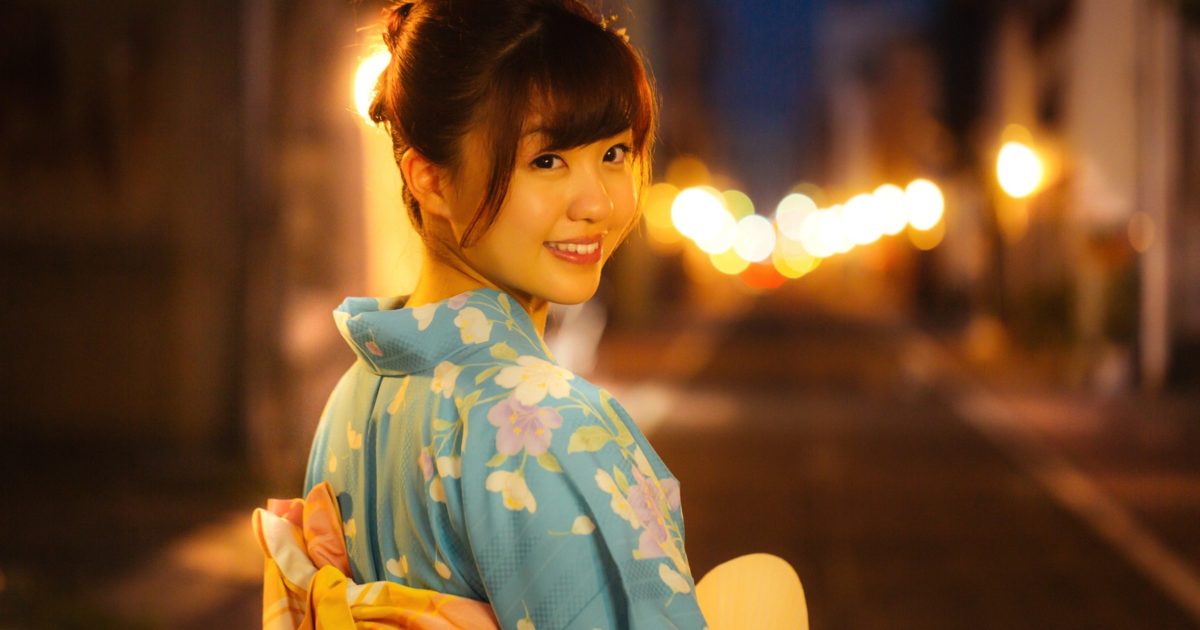 お祭りの帰り道、振り返る浴衣姿の彼女
