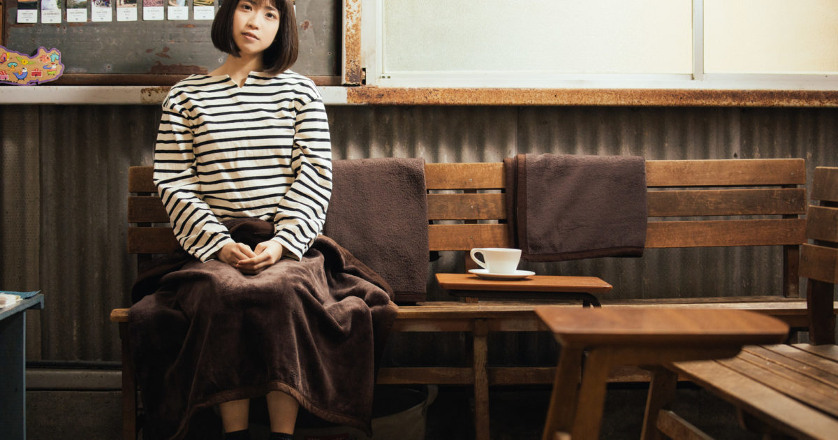 レトロな雰囲気のカリオモンズコーヒーの店内で一息つく女性
