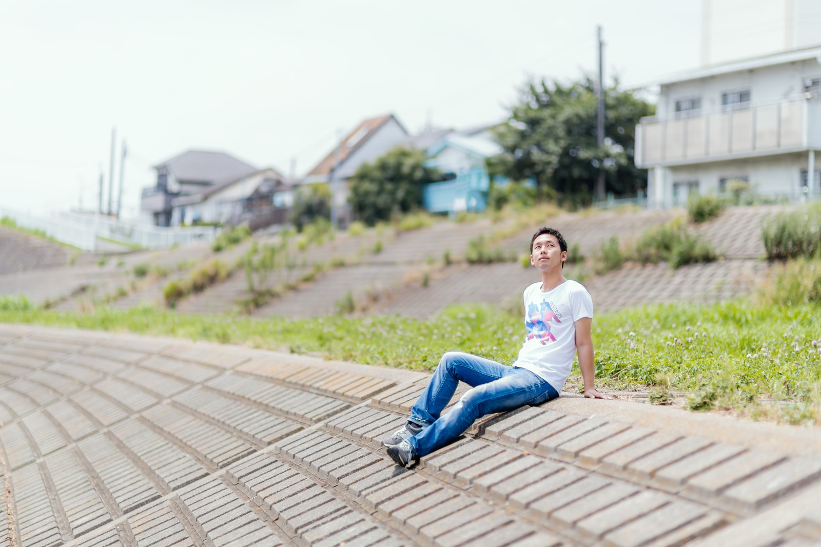 土手で日向ぼっこ中のフリーランスの男性