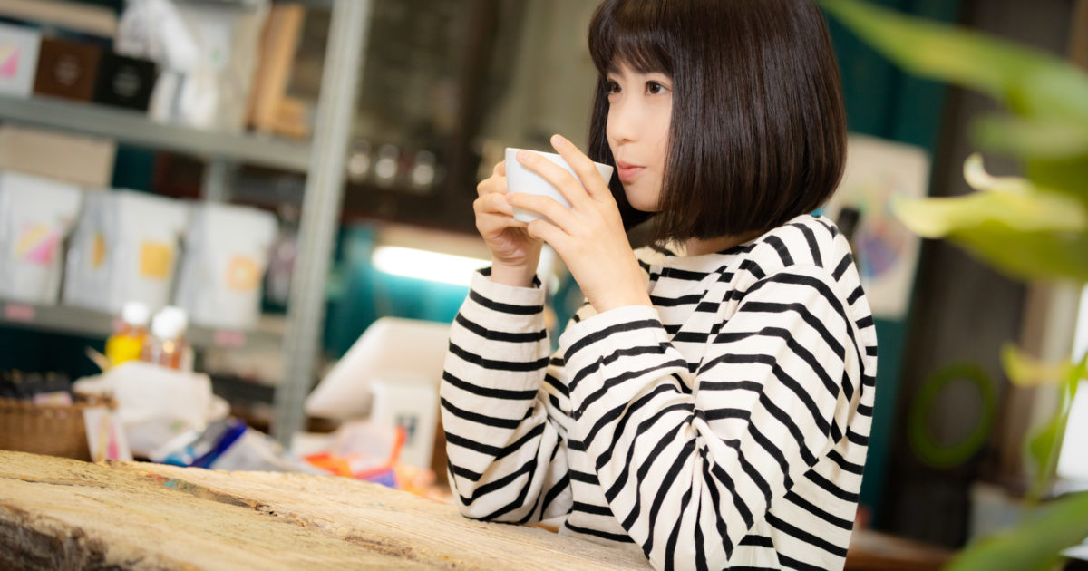 挽きたてのコーヒーを飲む女性