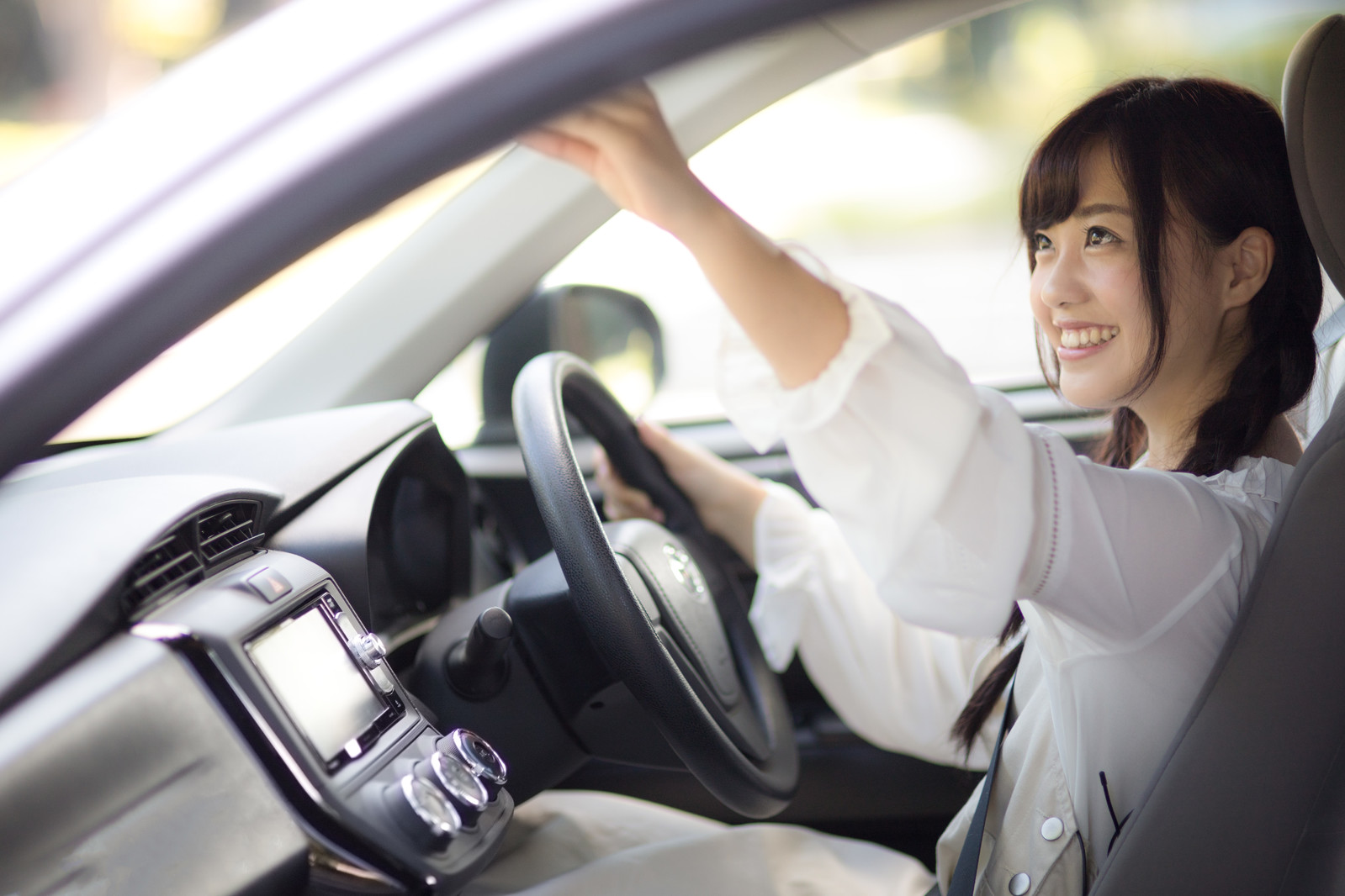 車内のバックミラーを調整する女子