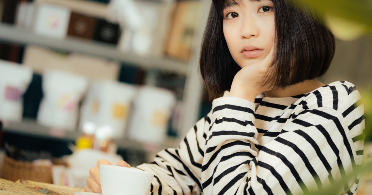 カフェで退屈そうにこちらを見つめる女性