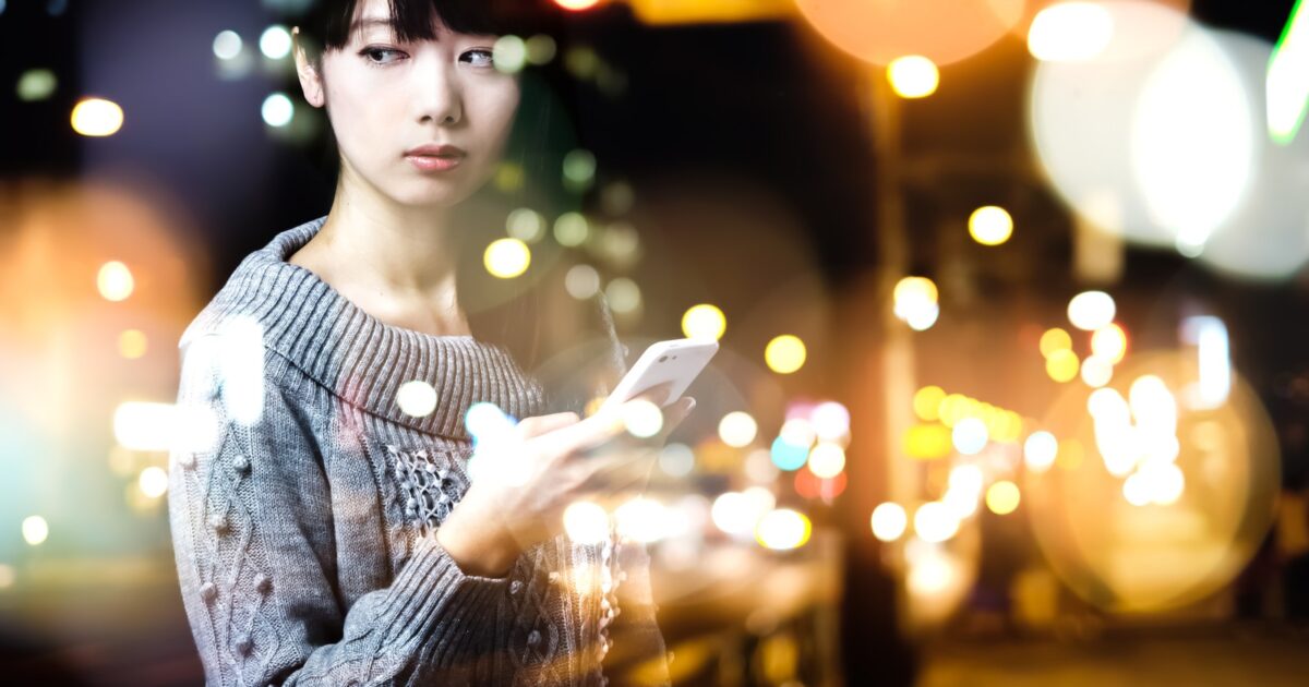 Clubhouseの招待を待つiphoneを持つ女性